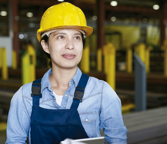 A woman with a work overall and a hardhat.