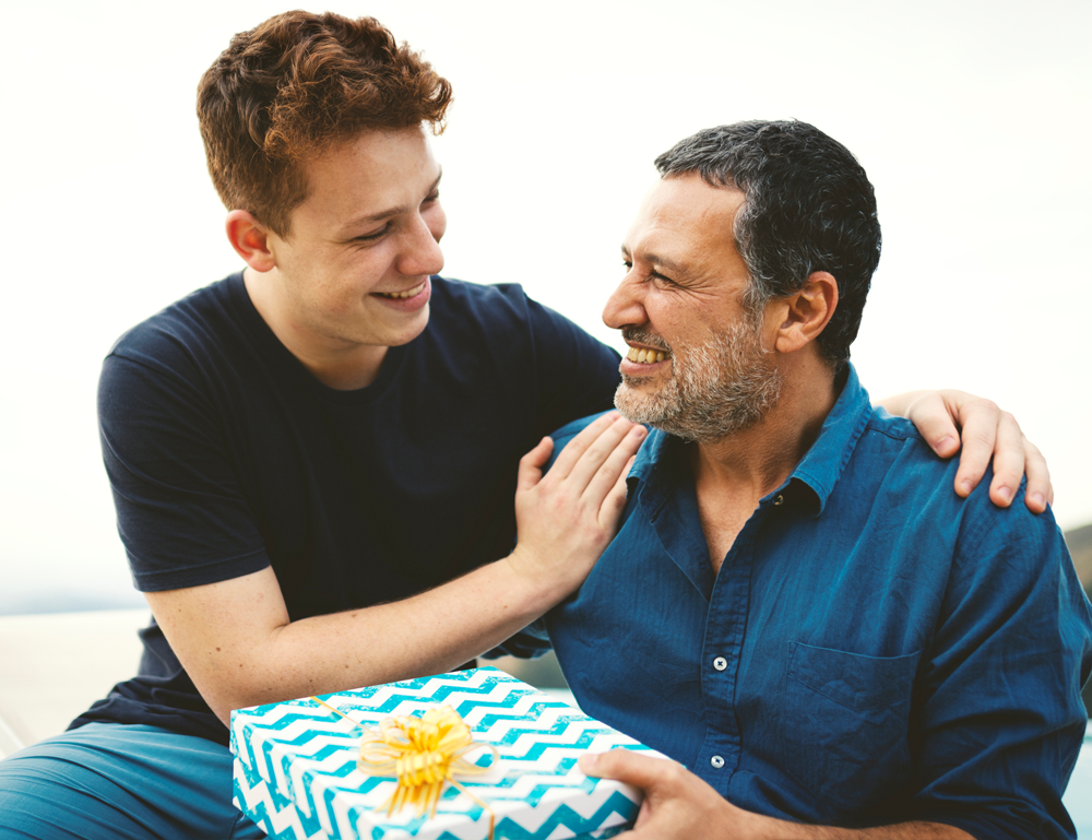 A person hugs and gives a gift to another person.