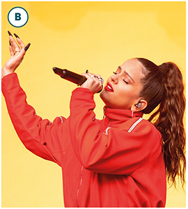 Rosalía holds a microphone, with mouth open and eyes closed.