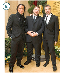 Alejandro González Iñárritu, Guillermo del Toro and Alfonso Cuarón pose together for a photo. A human-sized Oscar statue is behind them.